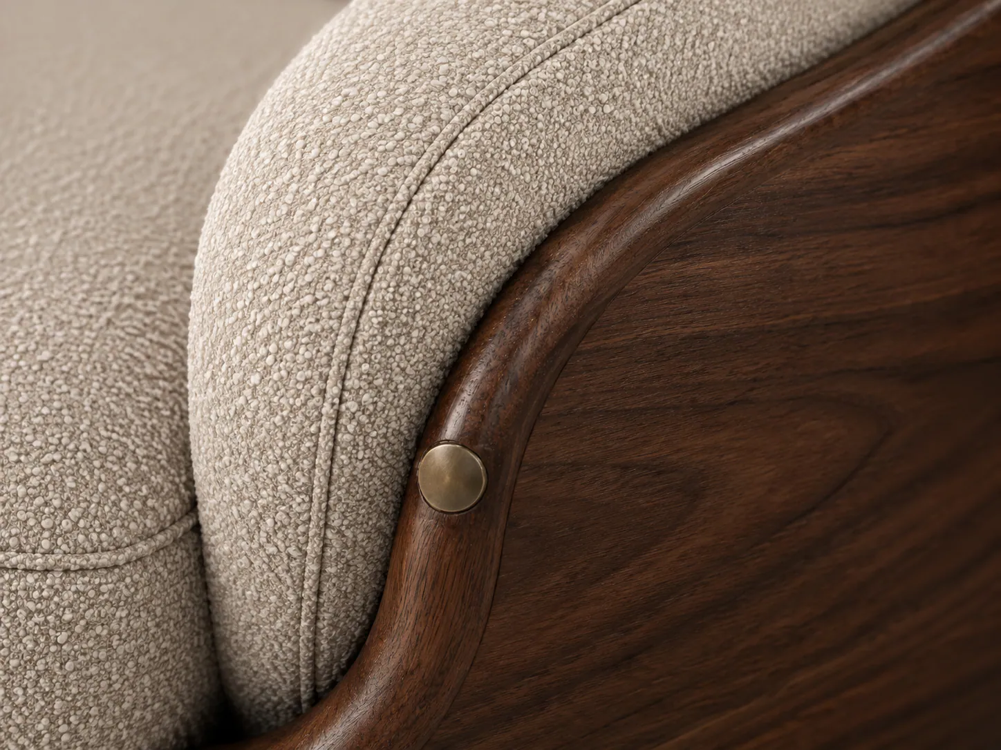 Close view of bouclé upholstery meeting a curved walnut shell